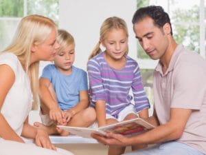 Rodzice i dwójka dzieci czytają książkę.