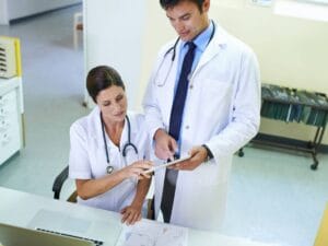 Dwoje lekarzy rozmawia nad dokumentami.