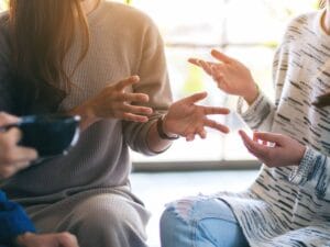 Gestykulujące dłonie ludzi w trakcie rozmowy.