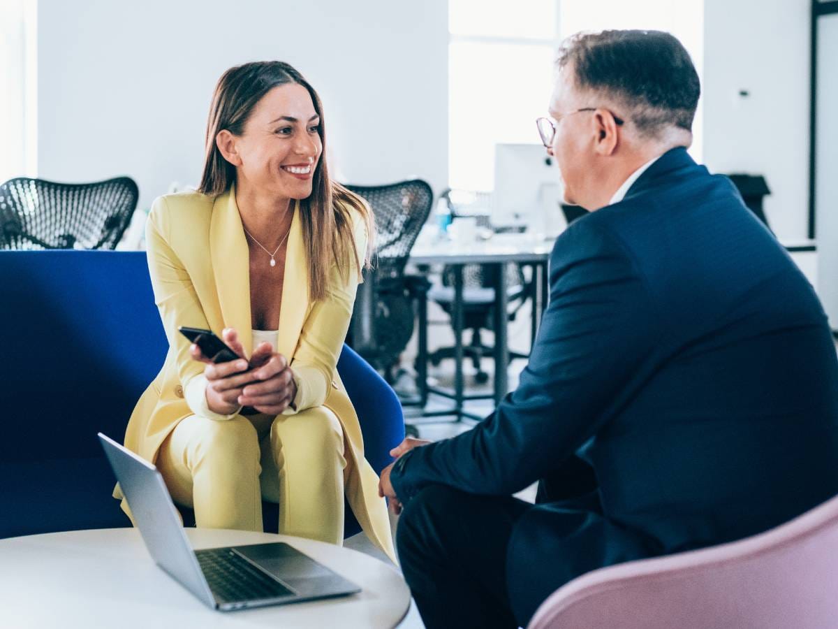Młoda kobieta i starszy mężczyzna rozmawiający w biurze