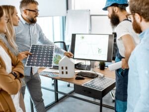 Grupa ludzi nad makietą budynku.