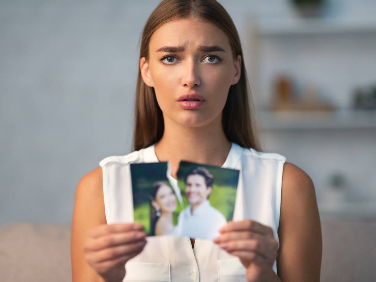 Kobieta ze zdjęciem, które rozrywa na pół.