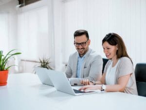 Para ludzi przed laptopami.