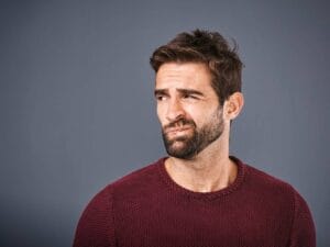 Mężczyzna ze skrzywioną miną.