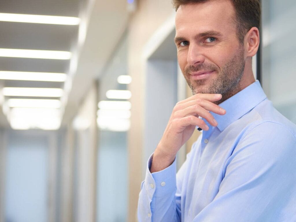 Mężczyzna w białej koszuli na biurowym korytarzu