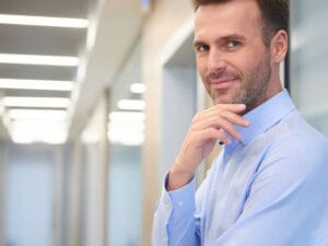 Mężczyzna w białej koszuli na biurowym korytarzu