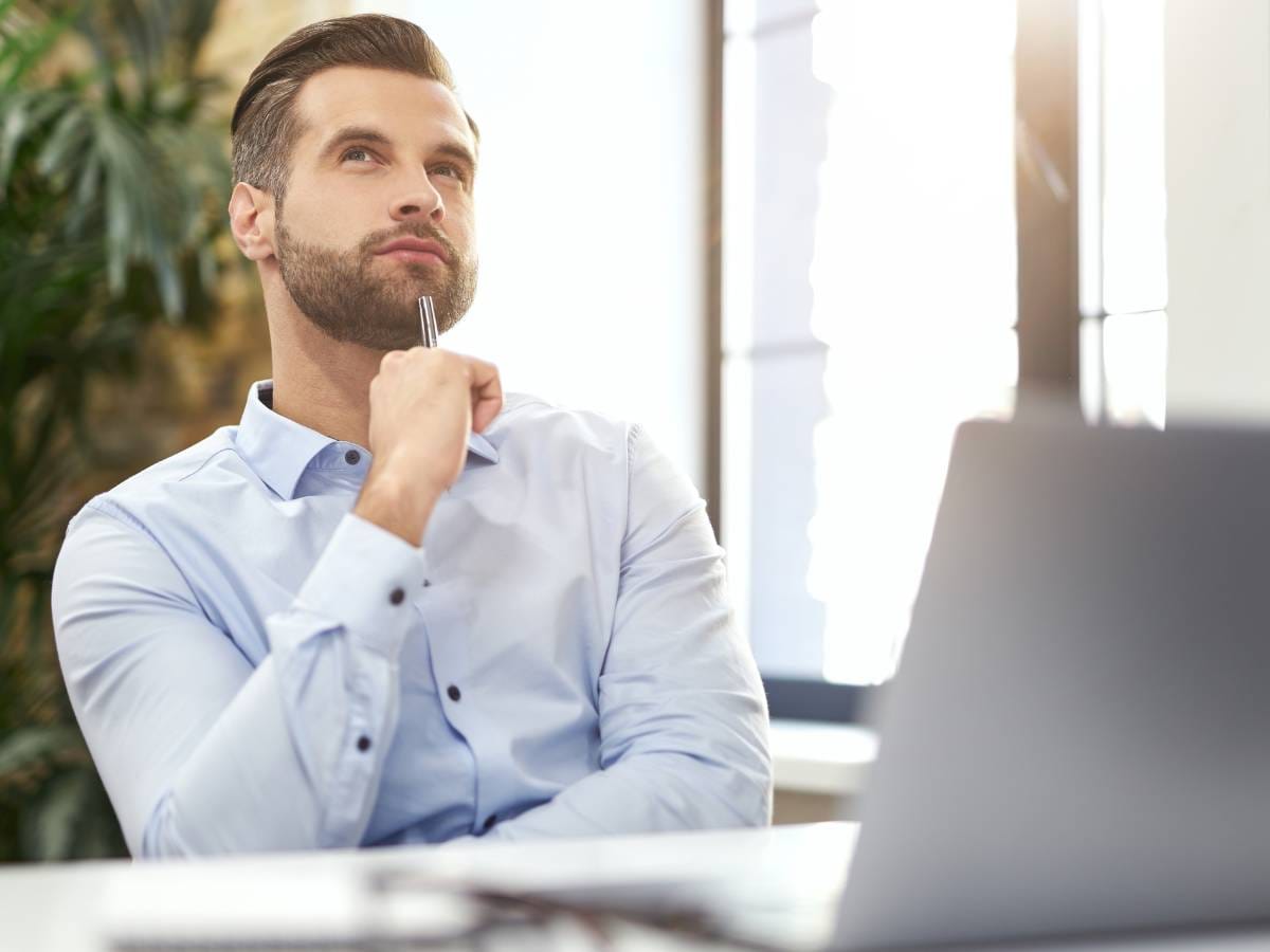 Zamyślony człowiek przed laptopem