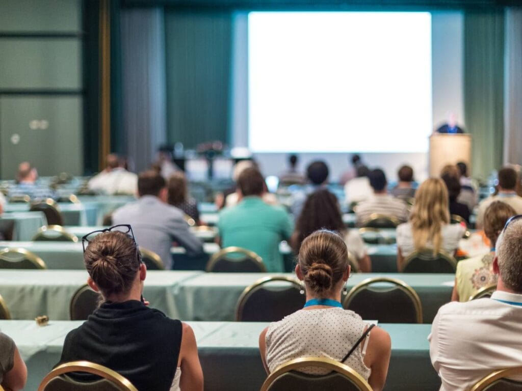 Wykład naukowy - widownia z gronem ludzi i scena