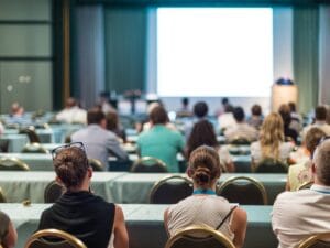 Wykład naukowy - widownia z gronem ludzi i scena