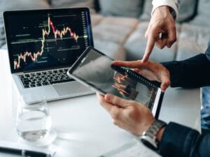 Tablet i laptop z różnymi danymi , trzymany w dłoniach mężczyzny.