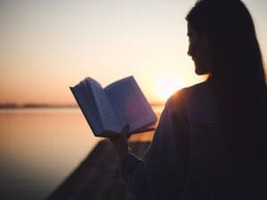 Kobieta z książką i zachód słońca