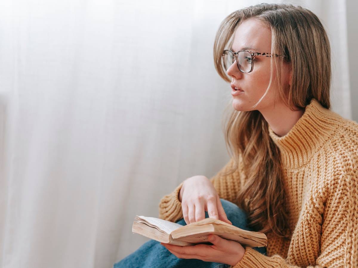 Zamyślona kobieta z książką.