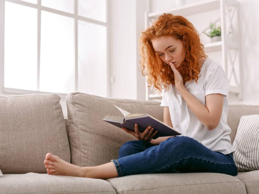 Kobieta z książką na kanapie