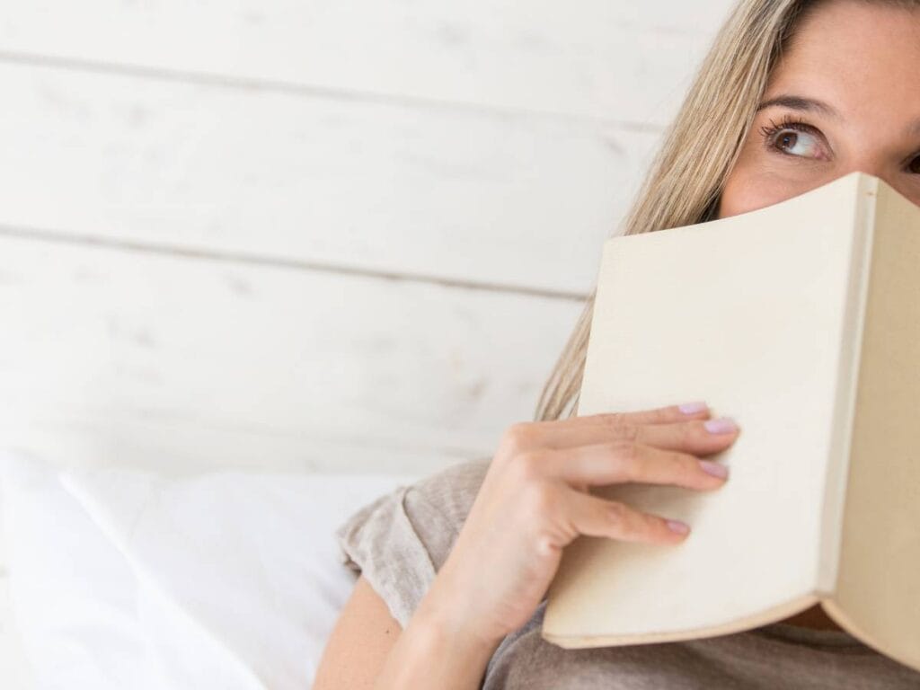 Kobieta zasłania się książką