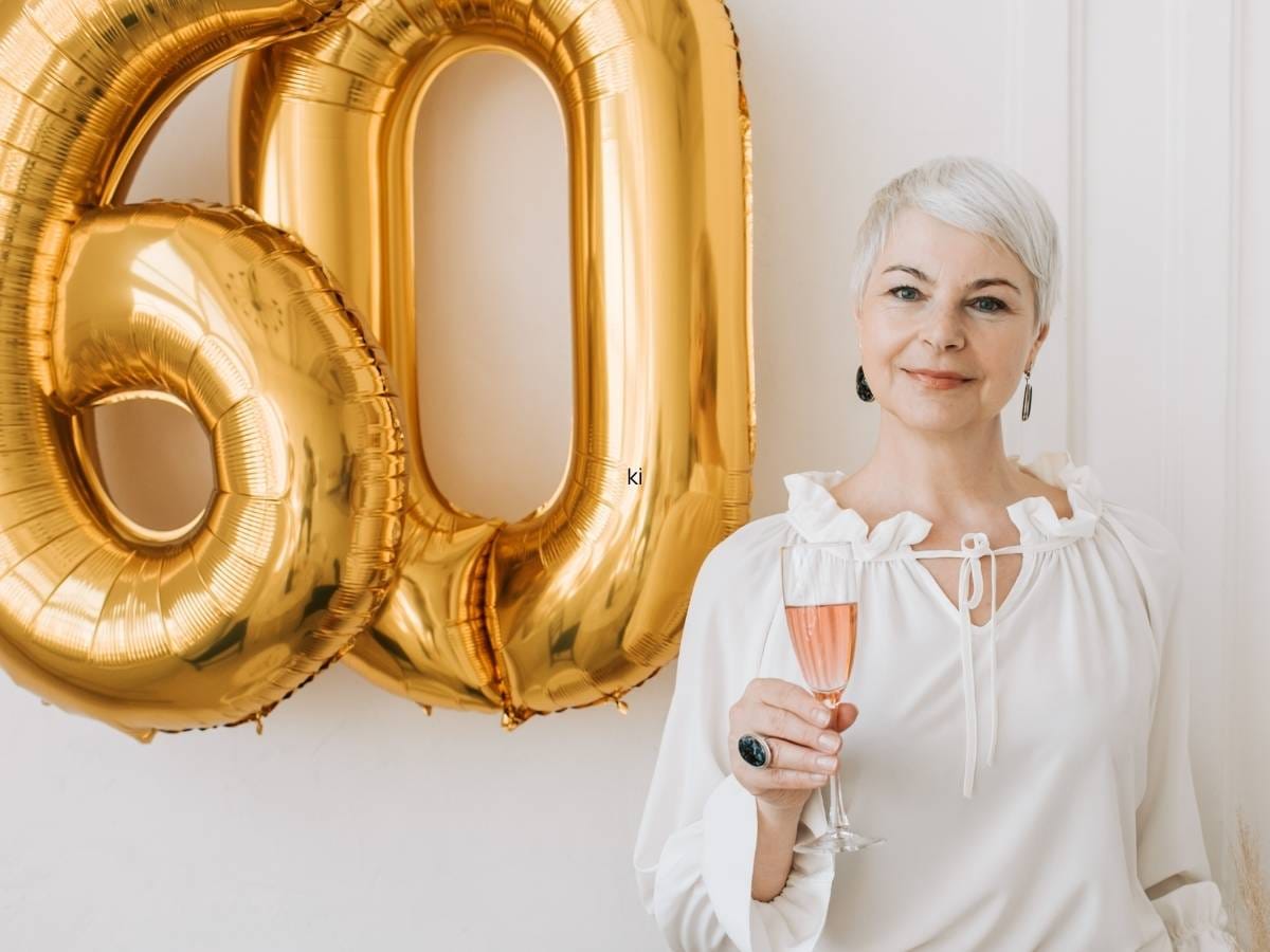 Liczba 60 ze złotych balonówy kobieta z kieliszkiem szampana
