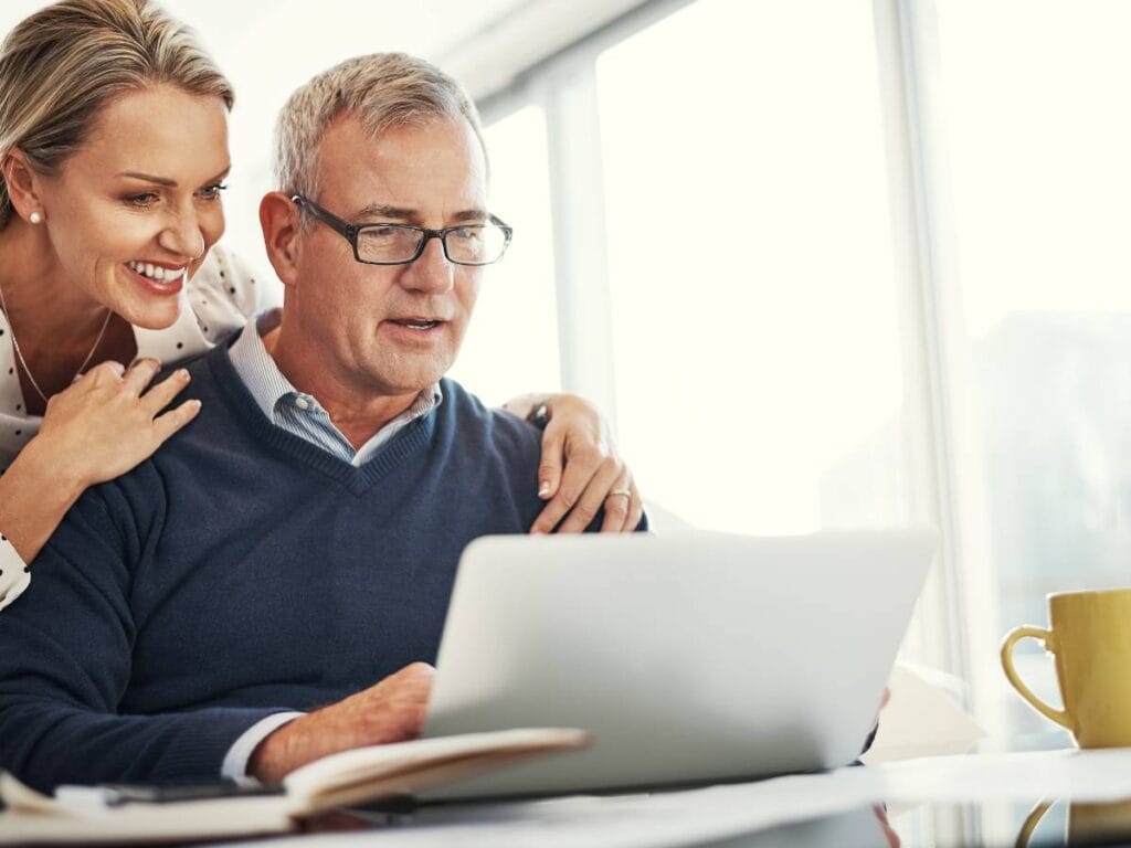 Starszy pan z dziewczyną przed laptopem