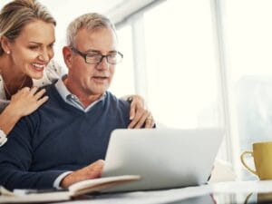 Starszy pan z dziewczyną przed laptopem